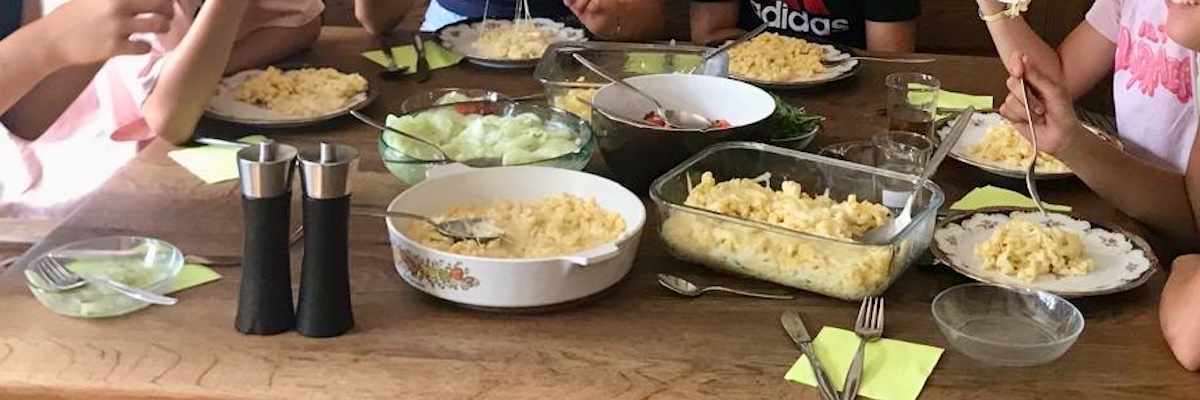 Gedeckter Tisch mit Spätzle und Salat.